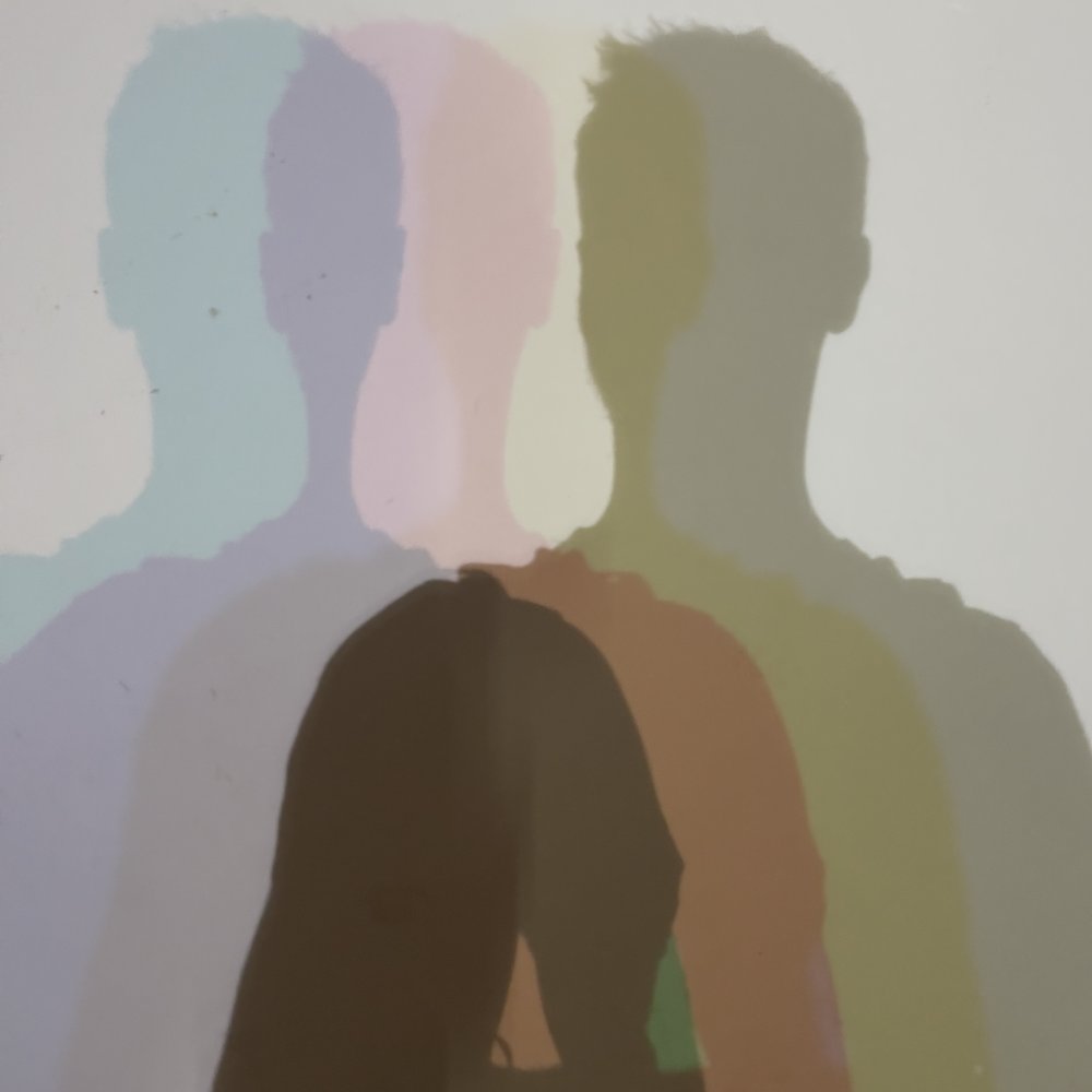 Shadows of Ingo Mercer on a wall in several pastel colours